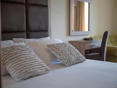 a bedroom with a bed with two pillows on it at Palma Rooms & Suites Budva in Budva