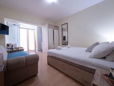 a bedroom with a large bed and a couch at Palma Rooms & Suites Budva in Budva