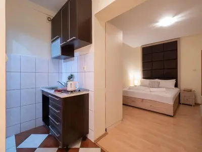 a small room with a bed and a kitchen at Palma Rooms & Suites Budva in Budva