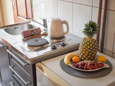 a plate of fruit on a kitchen counter with a pineapple at Palma Rooms & Suites Budva in Budva