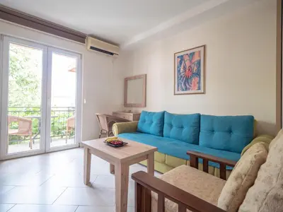 a living room with a blue couch and a table at Palma Rooms & Suites Budva in Budva
