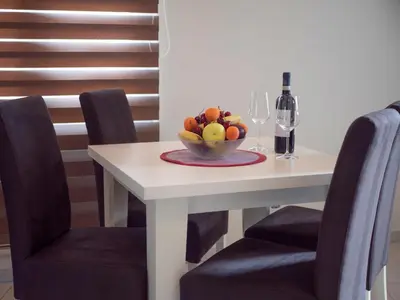 a table with a bowl of fruit and a bottle of wine at Palma Rooms & Suites Budva in Budva
