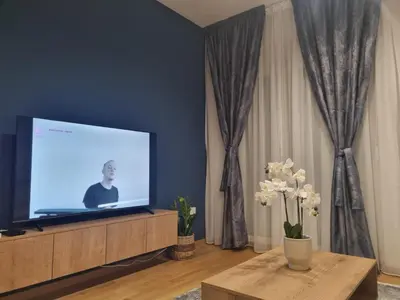 a living room with a flat screen tv on a cabinet at Old Town Residence in Podgorica