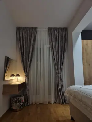 a bedroom with a bed and a window with curtains at Old Town Residence in Podgorica