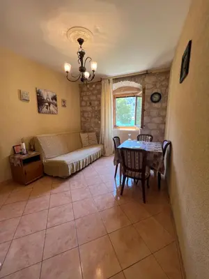 a living room with a bed and a table and chairs at Tetka Apartments in Kotor