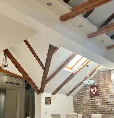 a room with wooden beams and white ceilings at Tetka Apartments in Kotor