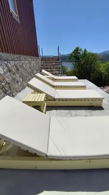 a group of benches sitting next to a building at Above the Lake in Rogani