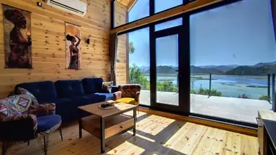 a living room with a blue couch and large windows at Above the Lake in Rogani