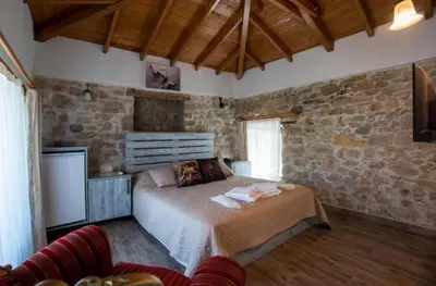 a bedroom with a bed and a stone wall at lifekotor in Kotor