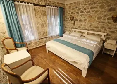 a bedroom with a large bed and two chairs at lifekotor in Kotor
