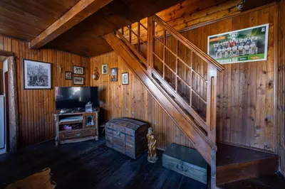 a living room with a staircase and a television at Montenegro Rustic House I in Bjeloši