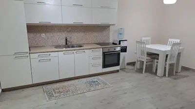 a kitchen with white cabinets and a table with chairs at Guest apartment Mina in Ulcinj