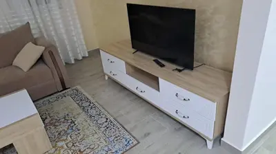 a living room with a flat screen tv on a cabinet at Guest apartment Mina in Ulcinj