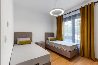a bedroom with two beds and a window at Apartment LEMON in Becici