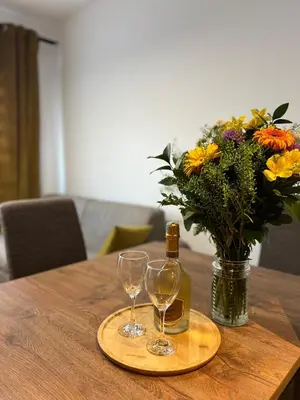 a bottle of champagne and two glasses on a table with flowers at Apartment LEMON in Becici