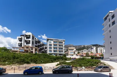 a group of cars parked in a parking lot with buildings at Apartment LEMON in Becici