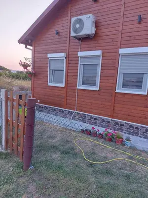 a red house with a heater on the side of it at Biser Štoja in Donji Štoj