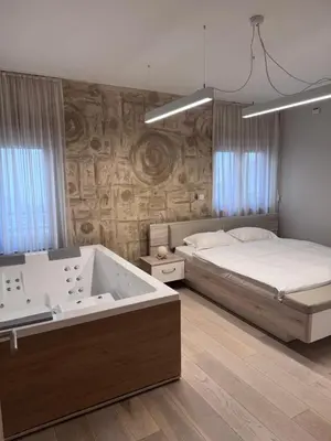 a bedroom with a large bed and a bath tub at Apartman Ari in Sveti Stefan