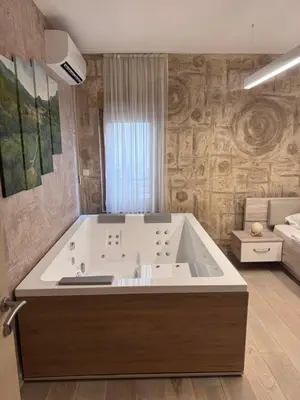 a bathroom with a large tub in a room at Apartman Ari in Sveti Stefan