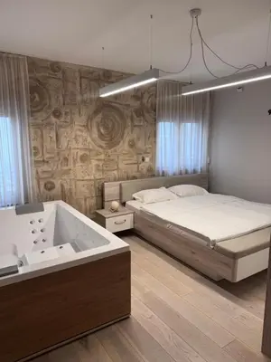 a bedroom with a bed and a bath tub at Apartman Ari in Sveti Stefan