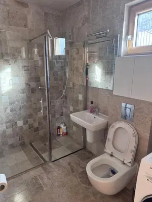 a bathroom with a shower and a toilet and a sink at Apartman Ari in Sveti Stefan