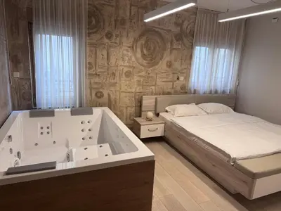 a bedroom with a bed and a bath tub at Apartman Ari in Sveti Stefan