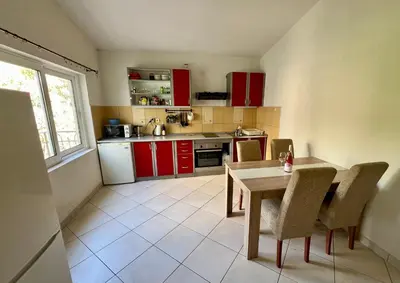 a kitchen with red cabinets and a table and chairs at Marcovici mountain breeze in Markovići