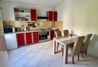 a kitchen with red cabinets and a table and chairs at Marcovici mountain breeze in Markovići