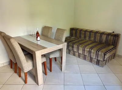 a dining room with a table and chairs and a couch at Marcovici mountain breeze in Markovići