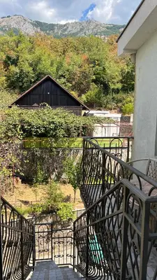 a balcony with a view of a building and trees at Marcovici mountain breeze in Markovići