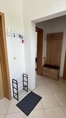 a room with a white wall with two shelves and a rug at Marcovici mountain breeze in Markovići