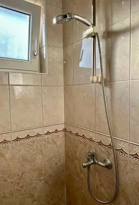 a shower with a shower head in a bathroom at Apartments Tijana in Tivat