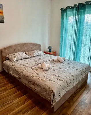 a bed with two pillows on it in a bedroom at Apartments Tijana in Tivat