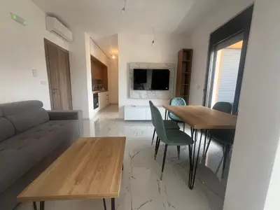 a living room with a couch and a table and chairs at Apartments Bella Notte in Ulcinj