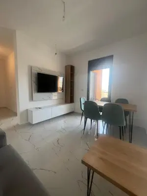 a living room with a table and chairs and a television at Apartments Bella Notte in Ulcinj