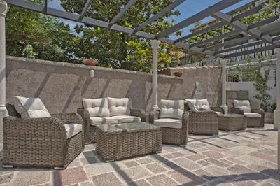 a group of wicker chairs and tables on a patio at Piazza Apartments 2 in Petrovac na Moru