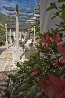 a patio with a pergola and some flowers at Piazza Apartments 2 in Petrovac na Moru