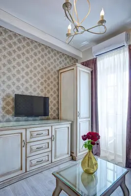 a living room with a tv and a vase with flowers on a table at Piazza Apartments 2 in Petrovac na Moru