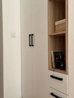 a white refrigerator next to a book shelf at Shi Apartment Bar in Bar