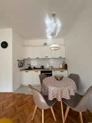 a kitchen with a table and chairs in a room at Shi Apartment Bar in Bar