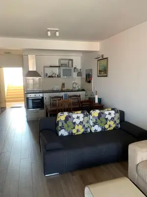 a living room with a couch and a kitchen at Stan 15 in Dobra Voda