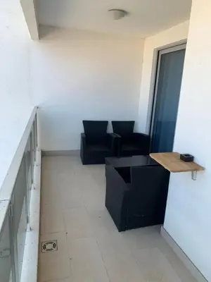 a living room with two chairs and a table at Stan 15 in Dobra Voda