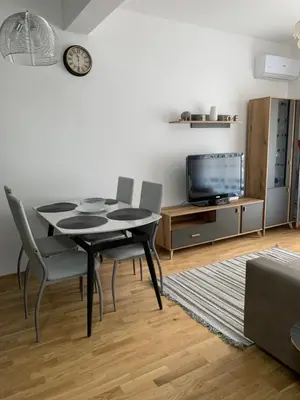 a dining room with a table and chairs and a tv at Mountain view in Budva
