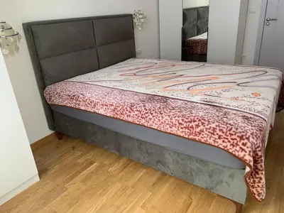 a bed in a room with a wooden floor at Mountain view in Budva