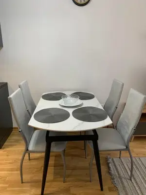 a white table with four chairs and a clock on the wall at Mountain view in Budva