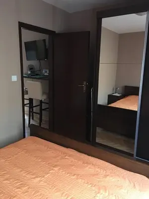 a mirror in a bedroom with a bed and a desk at Paladium Apartment in Budva