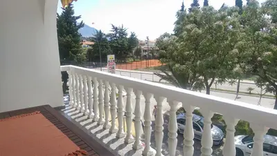 a balcony with a white railing and a view of a street at Paladium Apartment in Budva