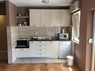 a kitchen with white cabinets and a microwave at Paladium Apartment in Budva