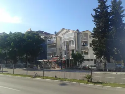 a large white building on the side of a street at Paladium Apartment in Budva
