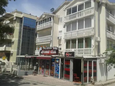 a tall white building with a store on a street at Paladium Apartment in Budva